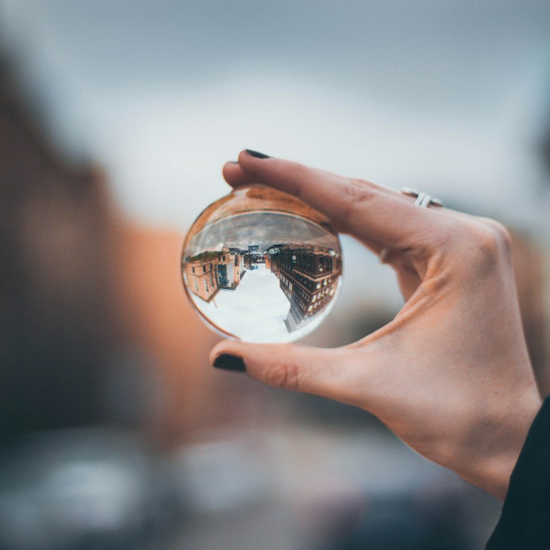 Coaching in der Lebensmitte, Life Coaching, Der Blick des Betrachters richtet sich auf eine durchsichtige Kugel in der rechten Hand einer Frau